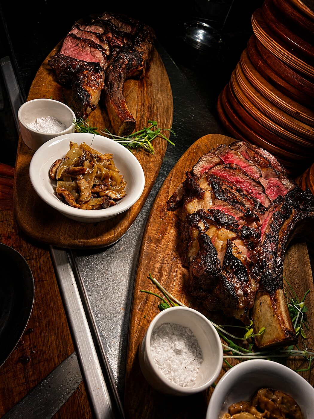 Bone-in ribeye, sliced and served on a wooden board with sea salt and caramelized onions at Renzo's St. Pete